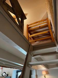 a staircase in a room with wooden ceilings at Le grenier d'Odette in Sainte-Gemme-la-Plaine