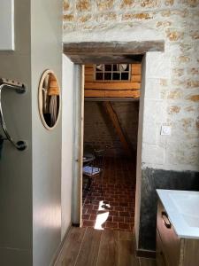 a kitchen with a brick floor and a brick wall at Le grenier d'Odette in Sainte-Gemme-la-Plaine