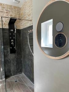y baño con espejo y ducha. en Le grenier d'Odette, en Sainte-Gemme-la-Plaine