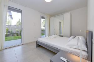 Habitación blanca con cama y ventana en Katya Resort Superior Apartments - MGH en Desenzano del Garda