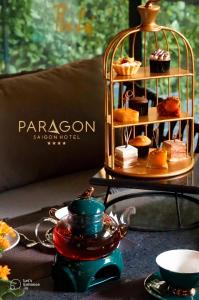 Una mesa con un plato de pasteles en un soporte. en Paragon Saigon Hotel, en Ho Chi Minh
