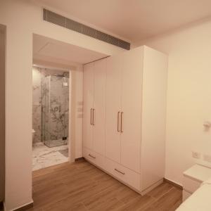 a bathroom with white cabinets and a shower at Hapalmah one, Jerusalem, Dira 1 in Jerusalem