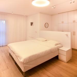 a white bedroom with a large bed in a room at Hapalmah one, Jerusalem, Dira 1 in Jerusalem