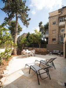 un patio con sillas y mesas frente a un edificio en Hapalmah one, Jerusalem, Dira 1, en Jerusalén