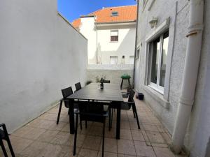 een patio met een tafel en stoelen op een balkon bij VILLA ST SOPHIE in Wimereux
