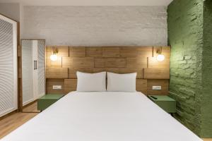 a bedroom with a large white bed and two lamps at Vatër Apartments in Tirana
