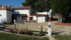 una casa con un jardín con flores delante en Domo Serra E Mesu, en Magomadas