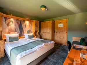 1 dormitorio con 1 cama grande y 1 mesa en Berghotel Sonnenbichl en Bad Wiessee