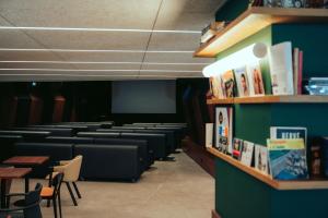 a waiting room with chairs and tables and bookshelves at JOST Auberge de Jeunesse Bordeaux Gare Saint Jean in Bordeaux