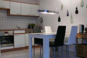 een keuken met een witte tafel en stoelen bij Ostsee Bungalow Stolteraa _ Objekt in Diedrichshagen