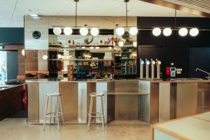 um bar num restaurante com dois bancos em JOST Auberge de Jeunesse Bordeaux Gare Saint Jean em Bordeaux