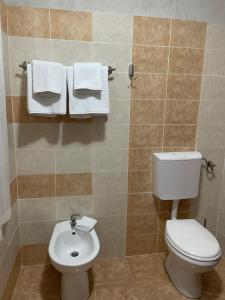 a bathroom with a toilet and a sink and towels at River Side in Statiunea Borsa
