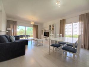 a living room with a table and a couch at Garden BEACH LUXURY APARTMENT Litoralmar in Portimão