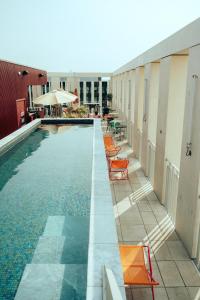 a swimming pool with orange chairs next to a building at JOST Auberge de Jeunesse Bordeaux Gare Saint Jean in Bordeaux