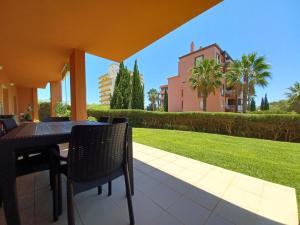 a patio with a table and chairs and a lawn at Garden BEACH LUXURY APARTMENT Litoralmar in Portimão