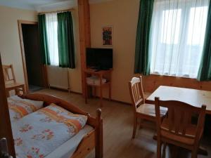 1 dormitorio con cama, mesa y comedor en Alpengasthof Fernblick en Mönichkirchen