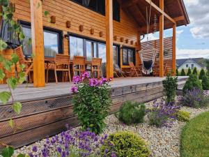a house with a porch with purple flowers at Panorama Tatry Chalets in Veľká Lomnica