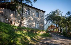 een oud stenen huis op een heuvel met een hek bij Guest House LALI in Mestia