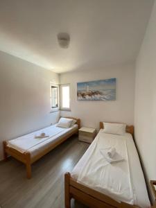 een slaapkamer met 2 bedden en een raam bij Privlaka's Sun&Sea in Privlaka