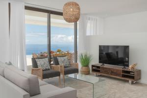 a living room with a couch and a tv at Premium villa panoramic sea-view Calheta Pearl in Estreito da Calheta