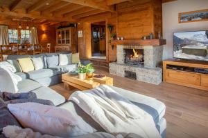 a living room with a couch and a fireplace at Chalet Morclan - OVO Network in Manigod