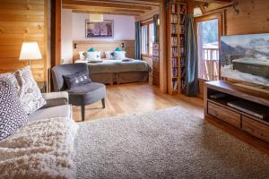 a living room with a bed and a couch and a tv at Chalet Morclan - OVO Network in Manigod