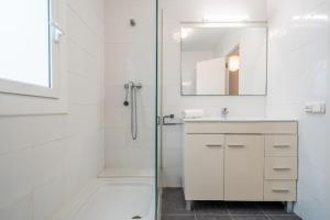 a white bathroom with a shower and a sink at HomeHolidaysRentals Palm Beach - Costa Barcelona in Canet de Mar