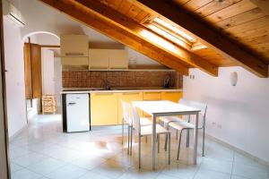 Residenza Ester في أمالفي: مطبخ مع طاولة وكراسي في غرفة