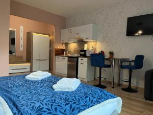 a kitchen with a bed and two chairs in a room at Mona Sun Apart in Gdynia