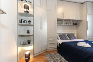 um quarto com 2 camas e armários brancos em New Belgrade Apartments, parking 5 eur per day em Belgrado