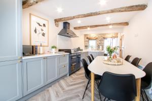 a kitchen with a table and chairs in a room at 3 Beck Head Kirkby Lonsdale in Kirkby Lonsdale