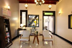 a dining room with a table and white chairs at The Egerton - Walk to Jonker - Ensuite - Heritage in Melaka