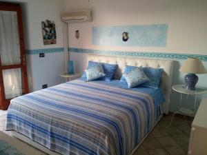 Un dormitorio con una cama con sábanas azules y blancas. en Villa Melina Appartamenti, en Santa Maria di Castellabate