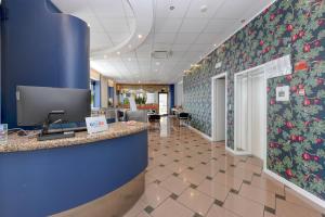 an office lobby with blue walls and a floral accent wall at Hotel Aurora in Desenzano del Garda