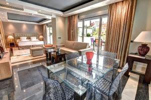 sala de estar con mesa de cristal y sillas en ArtPlatinum SUITES&APARTMENTS, en Benalmádena