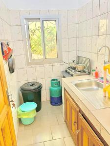 eine kleine Küche mit einem Waschbecken und einem Fenster in der Unterkunft Studio meublé Yaoundé Ekounou in Jaunde