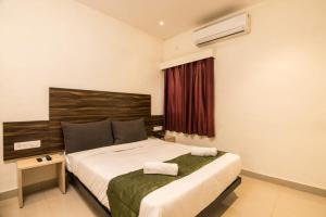 a bedroom with a bed and a window with a heater at HOTEL GOLDEN TULIPZ in Mumbai