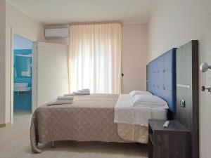 a bedroom with a large bed and a bathroom at Maresol Residence in Bagnara Calabra