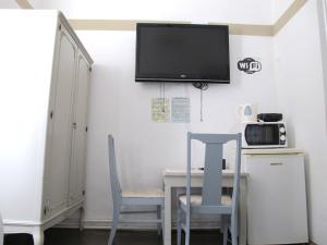 a dining room table with two chairs and a tv on the wall at Centar Guesthouse in Zagreb