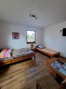 1 dormitorio con 2 camas, mesa y ventana en Pokoje Goscinne TOMASZ, en Międzywodzie