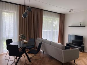 uma sala de estar com um sofá e uma mesa em Kuuse apartment em Pärnu