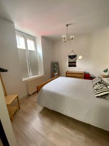 - une chambre avec un grand lit blanc et une fenêtre dans l'établissement LES PETITS ROYS - Proche centre ville - Cosy, à Châteauroux