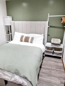 een slaapkamer met een groot wit bed en een telefoon bij Cosy Hideaway Lodge in Glan Gwna in Caeathro