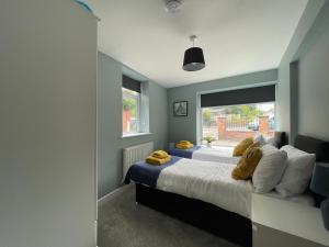1 Schlafzimmer mit 2 Betten und einem Fenster in der Unterkunft Silk Apartments Spondon in Derby