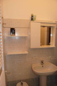 ein Badezimmer mit einem Waschbecken, einem WC und einem Spiegel in der Unterkunft B&B La Cà Cita in Cortazzone