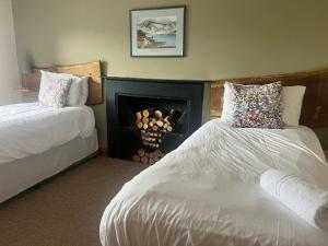 ein Hotelzimmer mit 2 Betten und einem Kamin in der Unterkunft New Ing Lodge in Shap