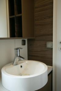 La salle de bains est pourvue d'un lavabo blanc et d'un miroir. dans l'établissement First Camp Lilleby, à Torslanda