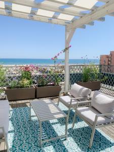 een patio met stoelen en uitzicht op het strand bij Hotel Villa Rosa Riviera in Rimini