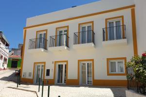 un edificio amarillo con balcones en una calle en SolRia Alvor, en Alvor