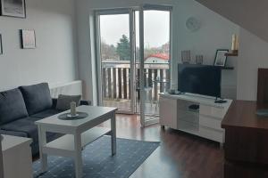 ブワディスワボボにあるMieszkanie Słoneczne Reja 2Bのソファとテーブルとテレビのあるリビングルーム